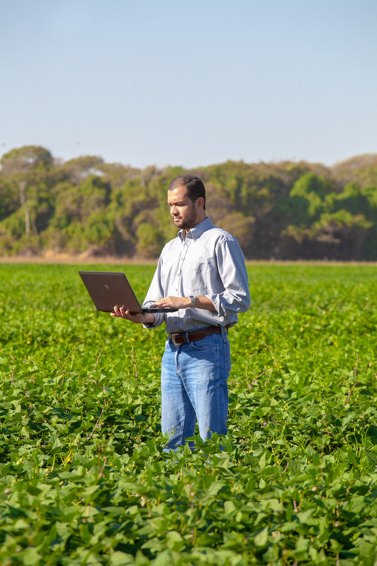 Man in White Dress Shirt and Blue Denim Jeans Standing on Green Grass Field